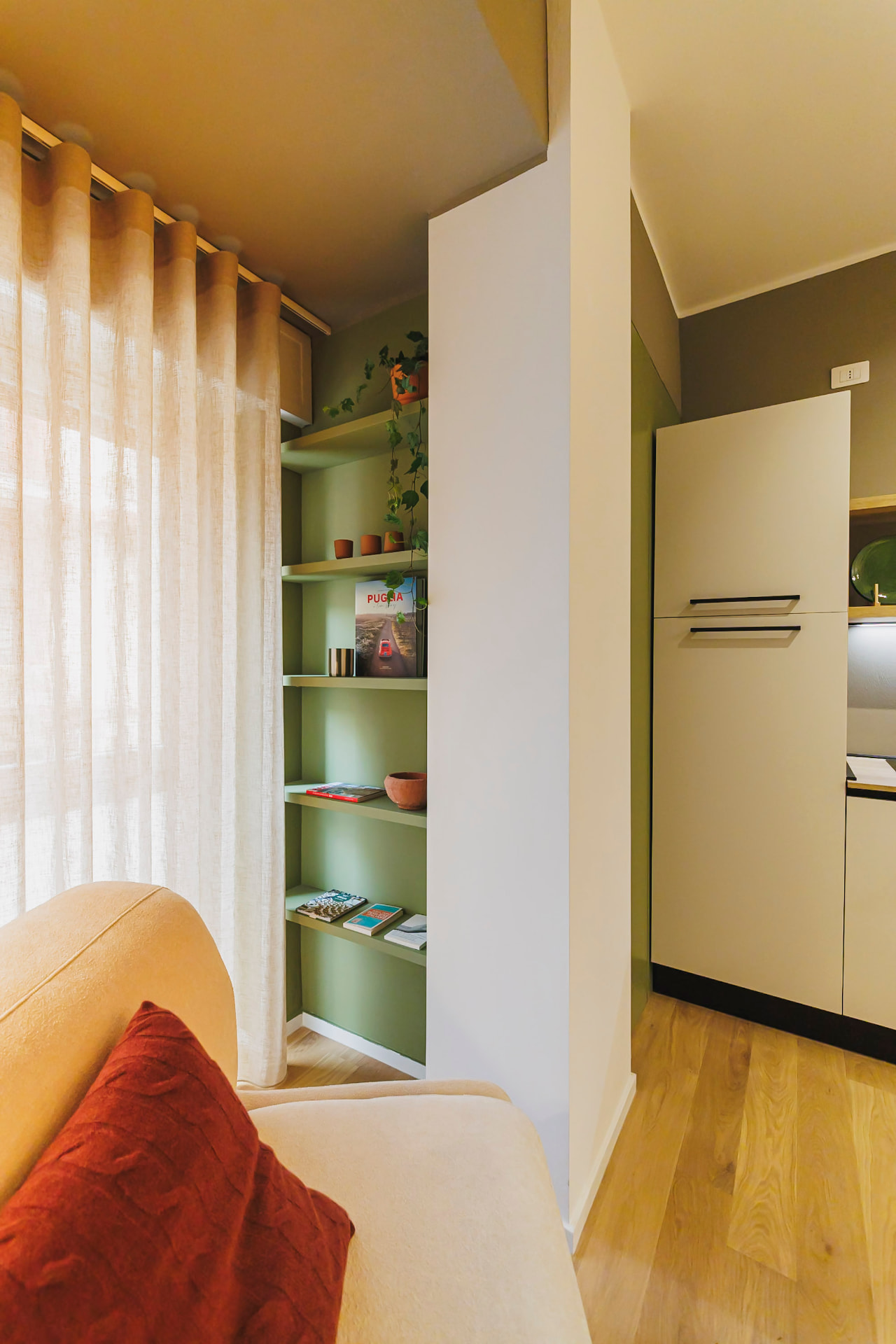 Angolo lettura del living con libreria verde e divano di Casa Bolero 48